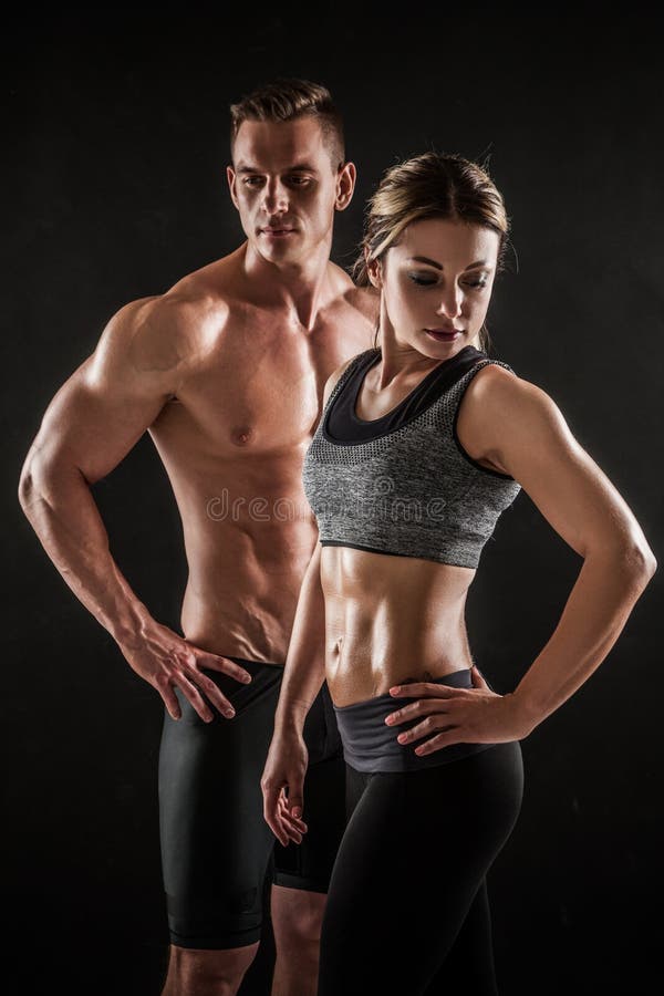 Sporty молодые пары представляя на черной предпосылке стоковое изображение